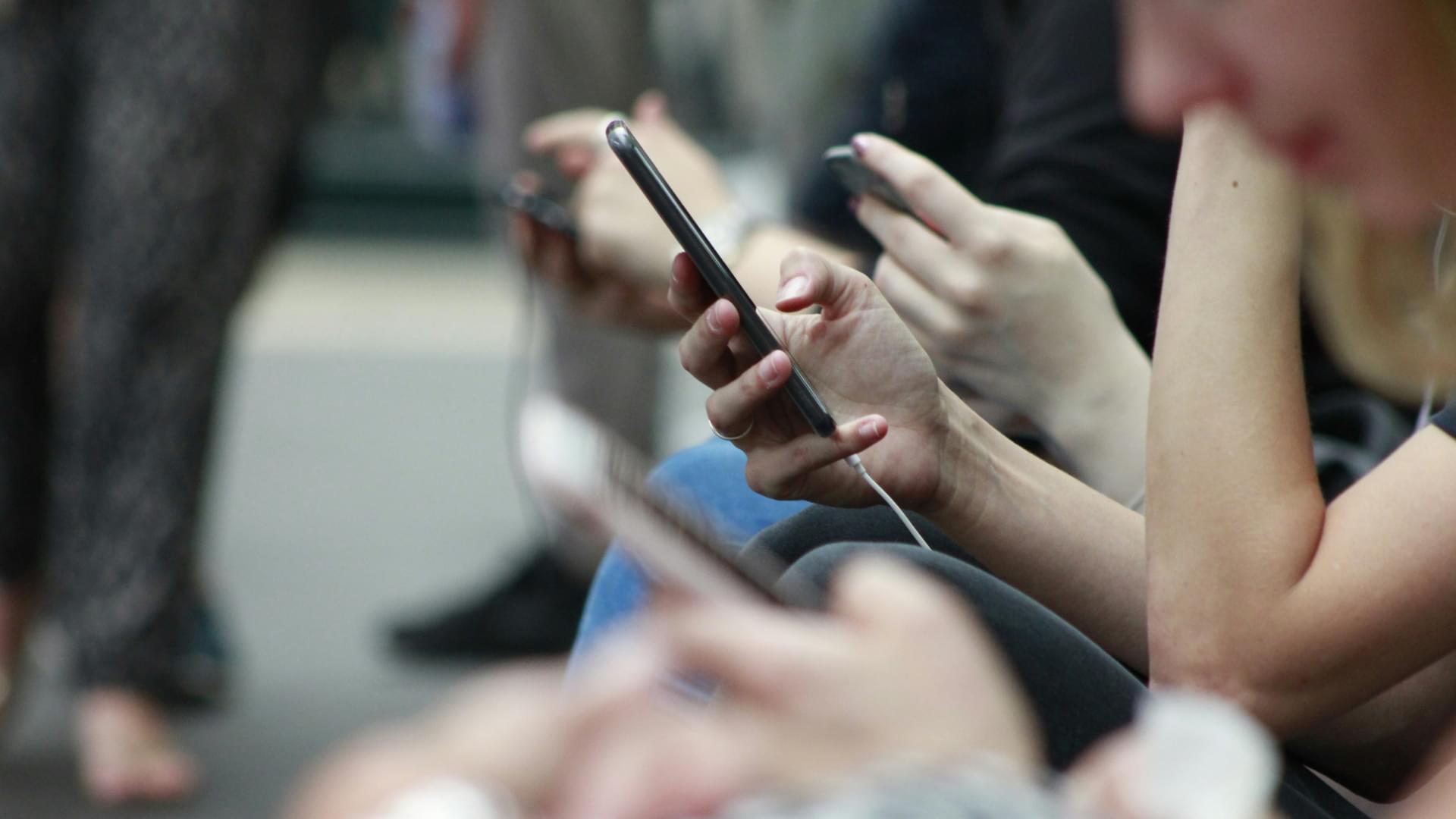 people on mobiles hands closeup