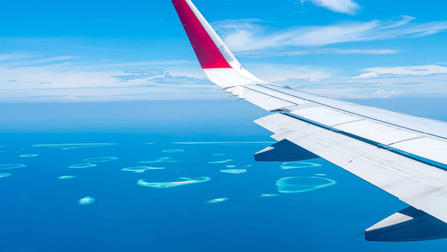 Plane wing over tropical island