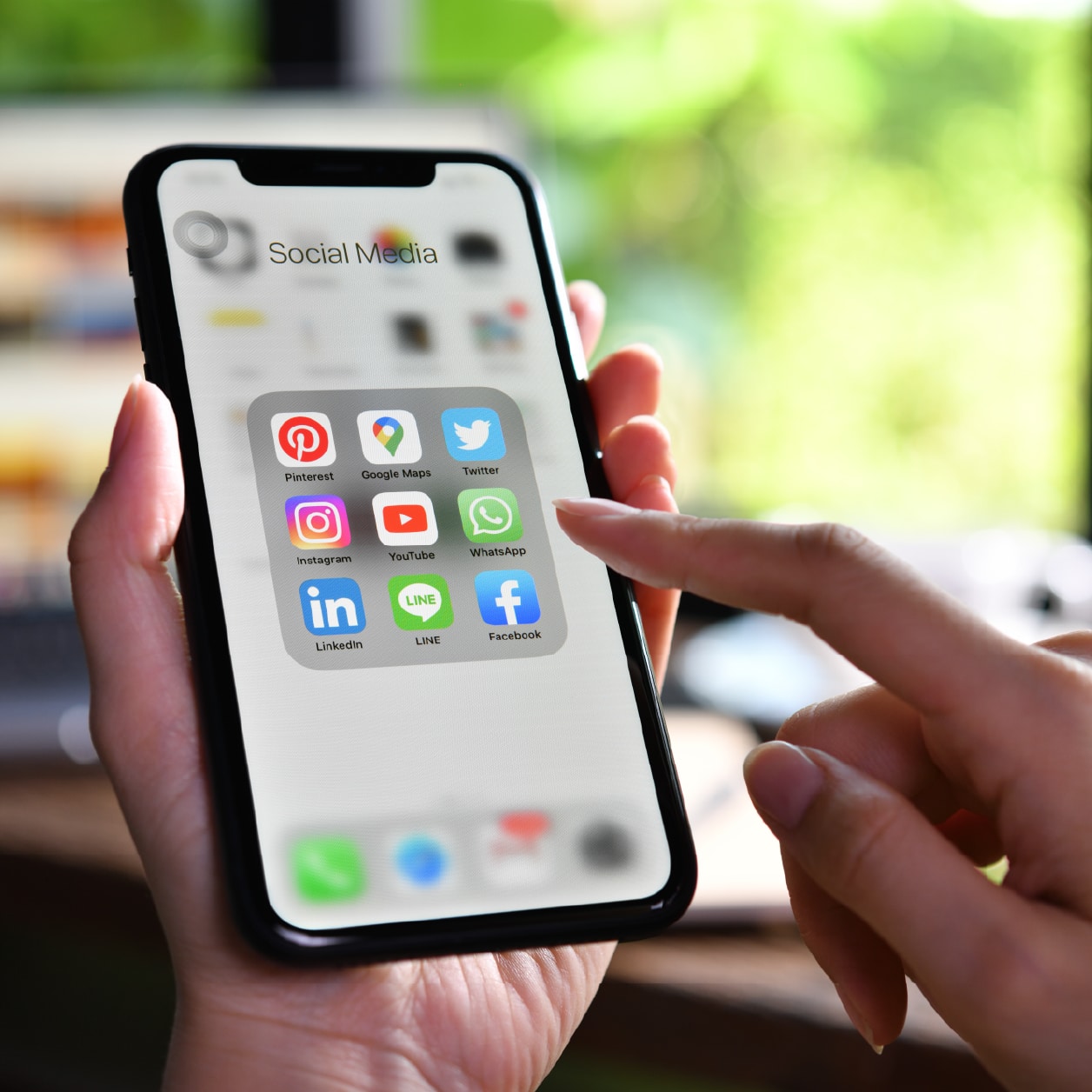 smartphone showing apps and hand