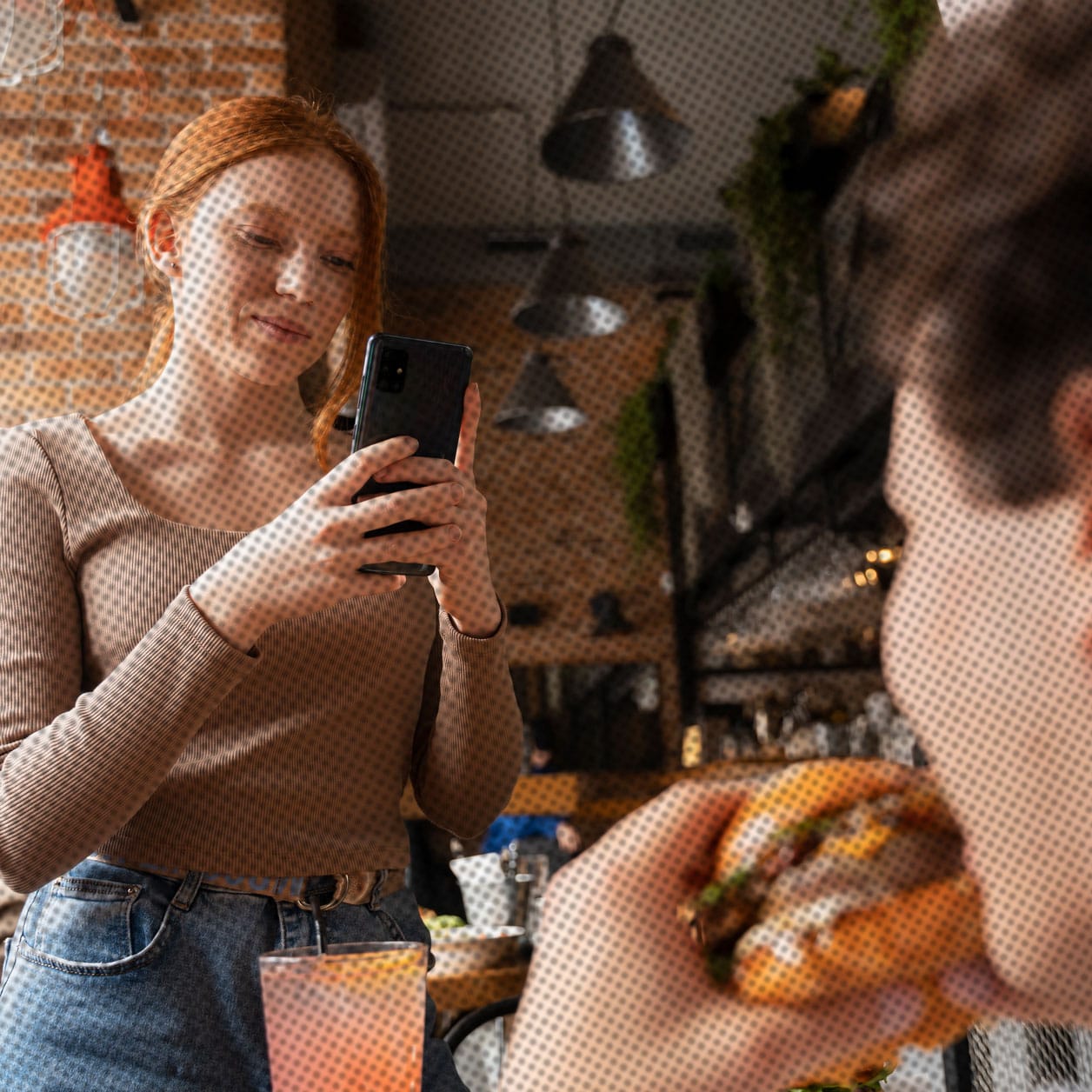 Person taking a picture of someone eating a burger