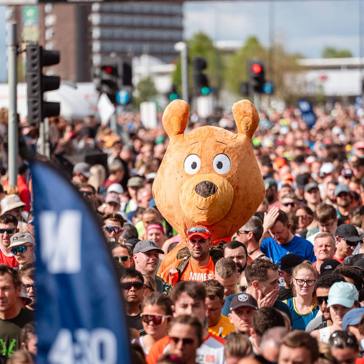 Running crowd with giant bear