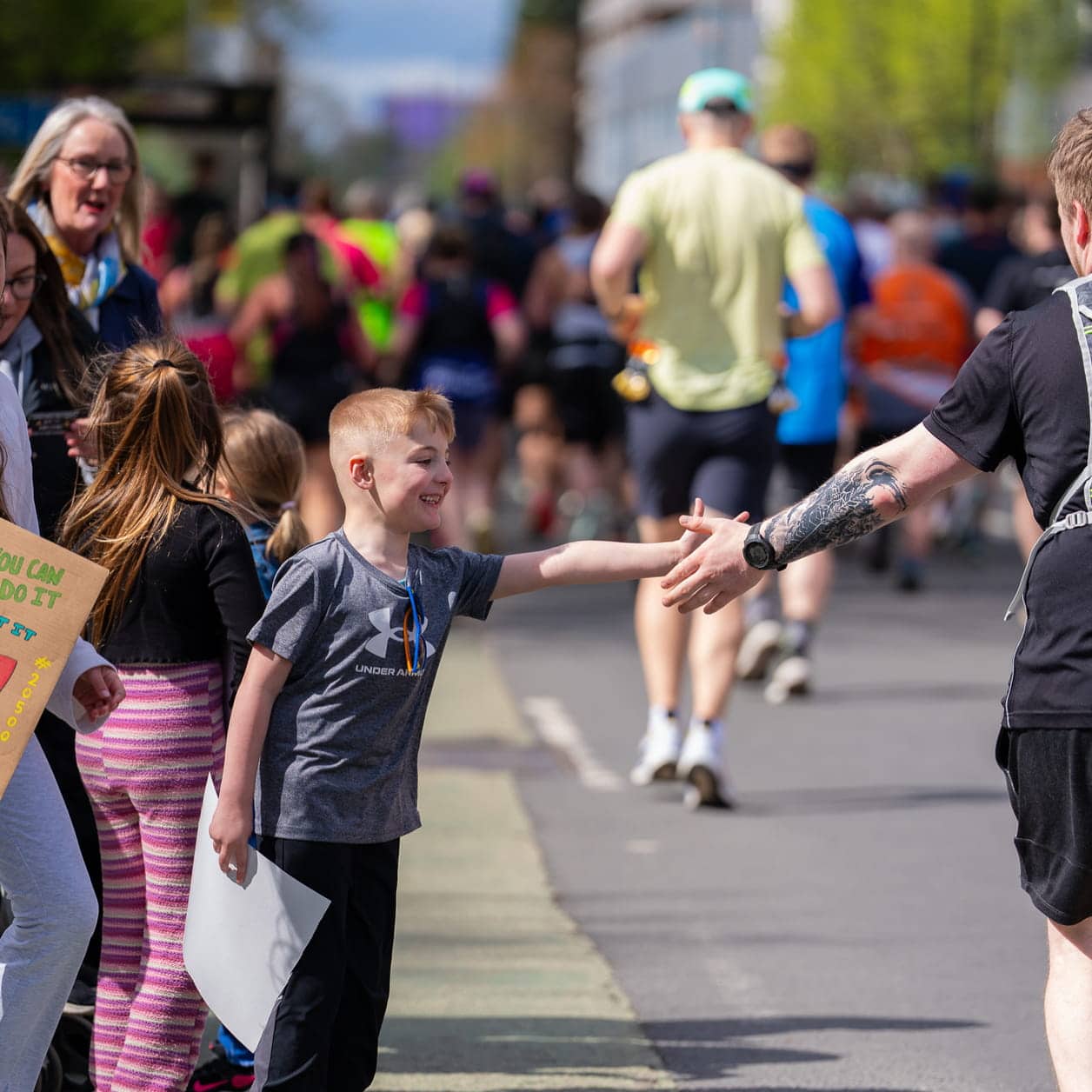 kid reaching out to runner
